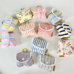 Flat lay of colorful floral and striped fabric earphone pouches with lace and hooks