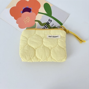 Vue détaillée de la pochette matelassée jaune avec coutures ondulées et cordon tressé