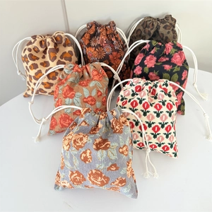 Detail of assorted corduroy drawstring bags in floral and leopard print patterns