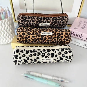 Three leopard print corduroy pencil cases in brown, orange and cream colors
