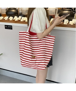 Détail du sac cabas en toile à rayures rouges et blanches avec larges poignées