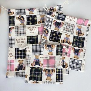 Three sizes of checkered bear canvas drawstring bags showing size comparison and details