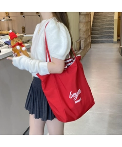Gros plan d'un sac cabas rouge avec texte blanc et doublure intérieure à rayures