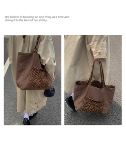 Detail of large tote bag with leopard print pocket and dual handles for daily use