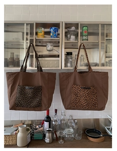 Detailed close-up of large leopard print canvas tote bag with front pocket and handles