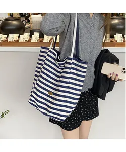 Détail d'un sac cabas en toile à rayures bleues et blanches avec une grande capacité