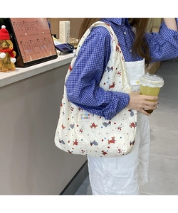 Detailed shot of quilted canvas tote bag with cartoon dog pattern shown on shoulder