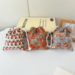 Detailed view of three corduroy drawstring bags with vintage floral patterns for storage