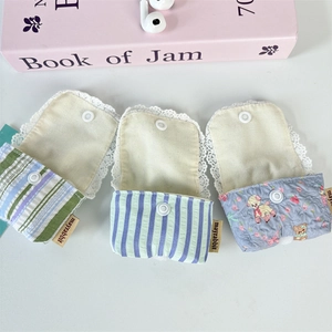 Detailed view of striped and bear print fabric earphone cases with lace trim and snap buttons