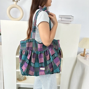 Détail d'un sac cabas à carreaux colorés avec plis et étiquette blanche style lifestyle