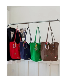 Detail of four mushroom and dog embroidery canvas tote bags with colorful rope charms