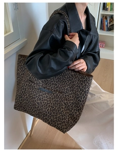 Chic leopard print tote bag styled with a leather jacket in a modern interior setting