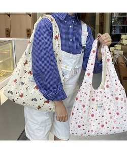Detail of quilted cotton tote bags with cartoon prints and colorful logo patches