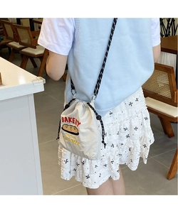 Detail of cream canvas bag with red Bakery print and black drawstring closure