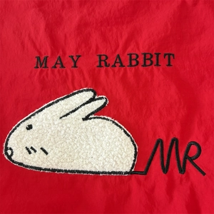 Close-up of May Rabbit plush embroidery on high-quality red nylon canvas fabric