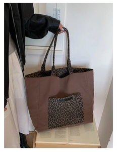Detail of a large leopard print tote bag showing the high-density fabric and front pocket