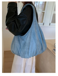 Side view of large sky blue suede hobo bag showing soft texture and spacious slouchy design