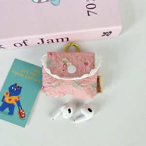 Close-up of pink quilted earphone case with cute puppy prints and lace details
