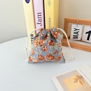 Detail of corduroy drawstring bag featuring blue-grey fabric and brown rose pattern