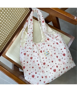 Close-up of quilted canvas tote with red cartoon puppy, strawberry, and heart patterns