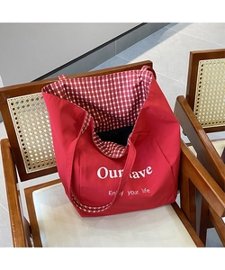 Detail of red canvas tote bag showing inner red-white checkered lining and printed text