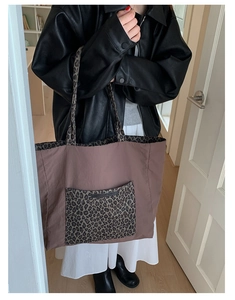 Macro detail of large leopard print pocket on durable nylon tote bag worn by a model