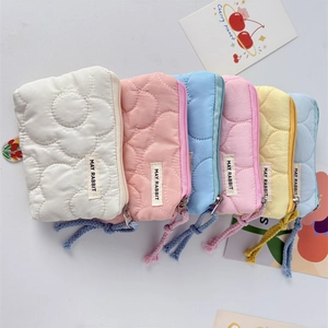 Détail de porte-monnaie matelassés à motifs floraux en diverses couleurs macaron
