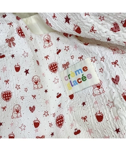 Close-up of embossed cartoon dog and strawberry patterns on white textured canvas fabric
