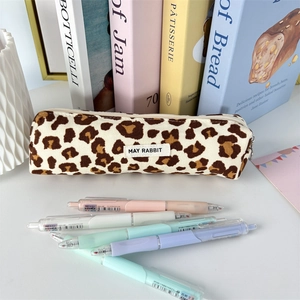 Detail of leopard print corduroy pencil case with woven label and colorful pens