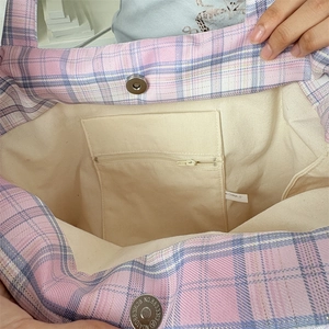 Détail du cabas à carreaux avec doublure en toile, poche zippée et fermoir magnétique