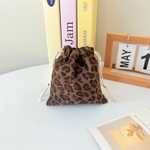 Close-up of leopard print corduroy drawstring pouch showing soft fabric and white ropes