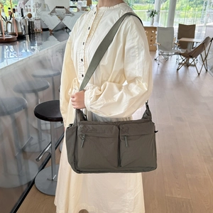 Détail de la bandoulière en nylon imperméable avec plusieurs poches zippées fonctionnelles