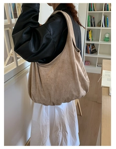 Detail of a large beige suede tote bag showing its soft texture and slouchy bohemian style