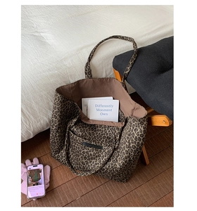 Close-up of leopard print tote bag featuring a front pocket and brown inner lining