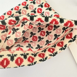 Detailed close-up of thick floral knit texture on a cream winter bucket hat fabric