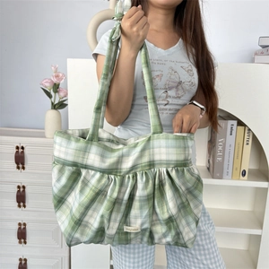 Détail du sac cabas à carreaux verts et blancs avec étiquette et texture en tissu plissé