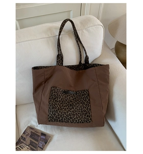 Macro view of leopard print pocket texture on brown nylon tote bag with logo detail