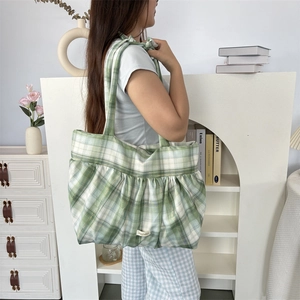 Détail du sac cabas à carreaux vert et blanc avec fermeture plissée et larges brides