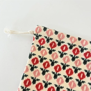 Detail of corduroy drawstring bag showing tulip print and soft ribbed texture