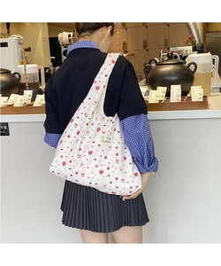 Close-up of large canvas shoulder bag with red floral pattern and crème glacée label