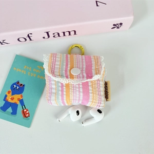 Macro detail of the fabric earphone pouch with pleated stripes and delicate lace trim