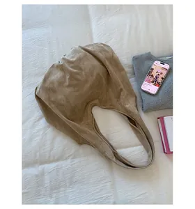 Close-up of khaki suede tote bag showing soft texture and spacious interior compartment