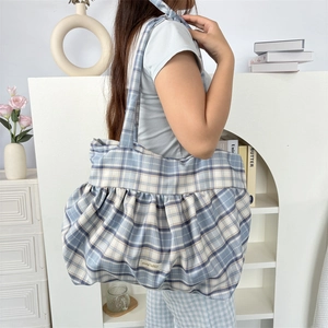 Détail du sac cabas à carreaux bleus avec bords à volants et étiquette tissée