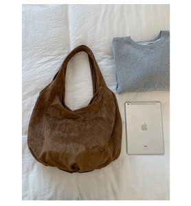 Brown suede tote bag shown with a tablet to demonstrate its large storage capacity