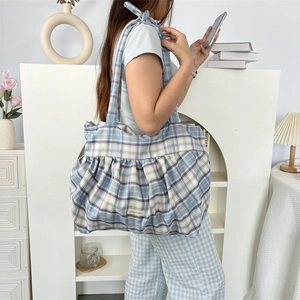 Détail d'un grand sac cabas à carreaux bleus et blancs avec volants et nœud de bandoulière