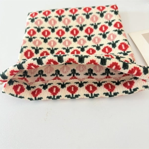 Close-up of mini corduroy drawstring bag with red and pink tulip floral patterns