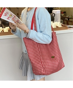 Macro view of red and white checkered canvas tote bag with large capacity for daily use