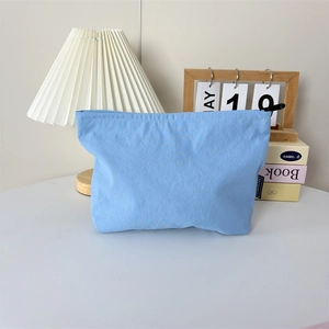 Gros plan d'une trousse de toilette en nylon bleu clair imperméable avec fermeture éclair