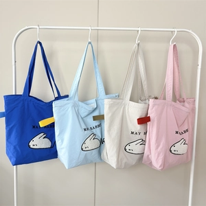 Detailed embroidery of cartoon rabbit and May Rabbit text on nylon tote bags in four colors