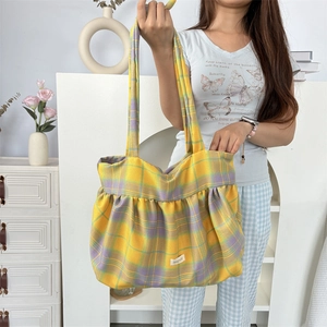 Détail du sac cabas à carreaux jaune et violet avec texture plissée et étiquette blanche